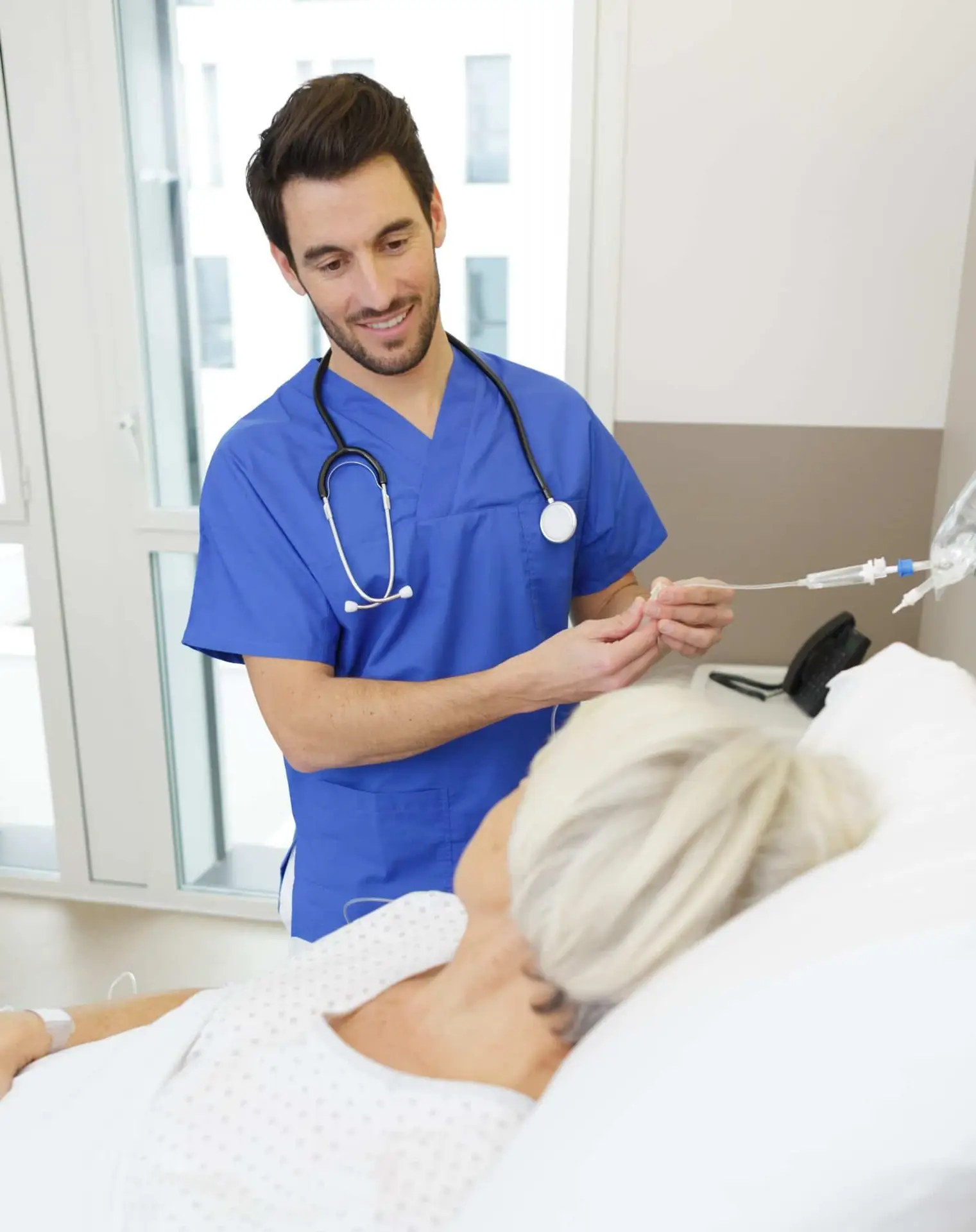 nurse adjusting older woman's IV